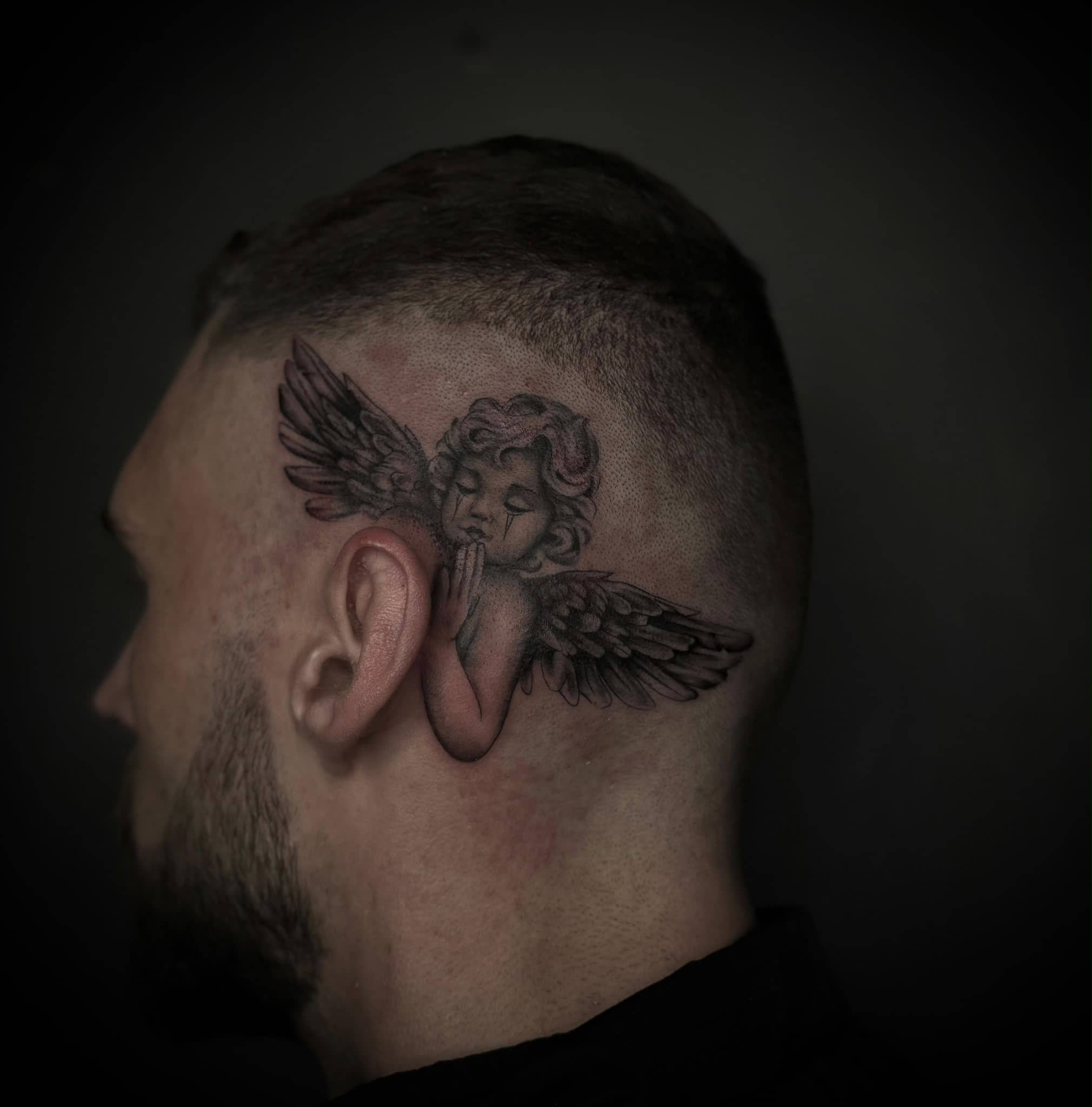 Black and Grey Cherub-Engel mit Fluegeln hinter dem Ohr am Kopf