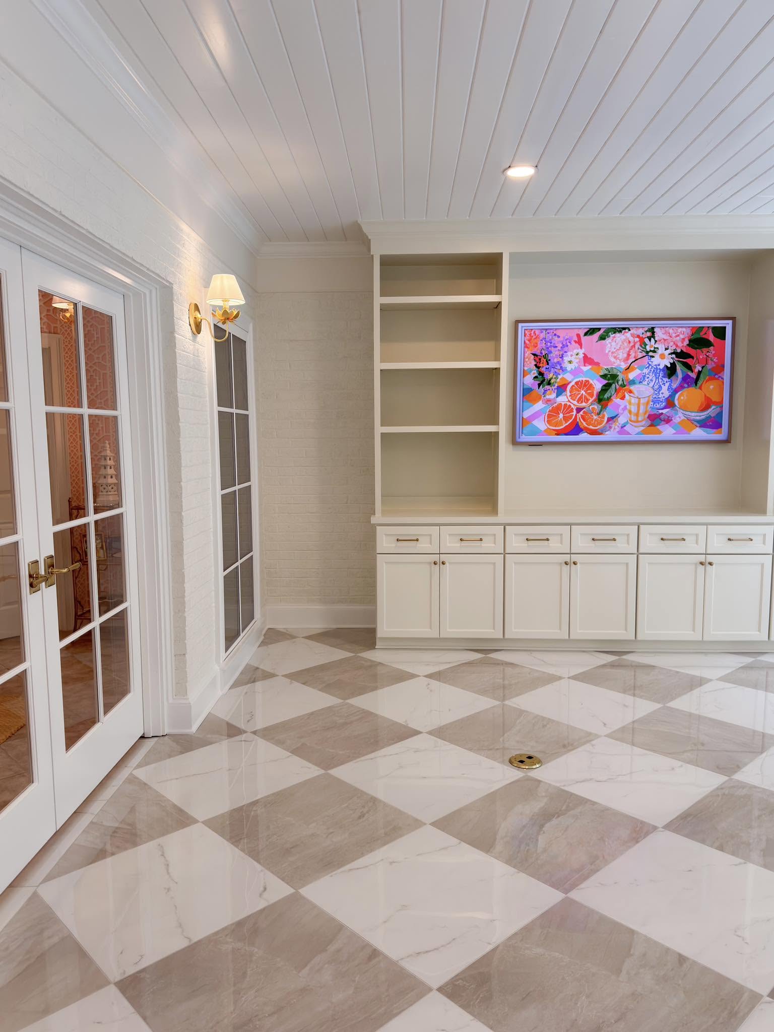 Custom gallery hallway with marble checkerboard floors, built-in cabinetry, and French doors