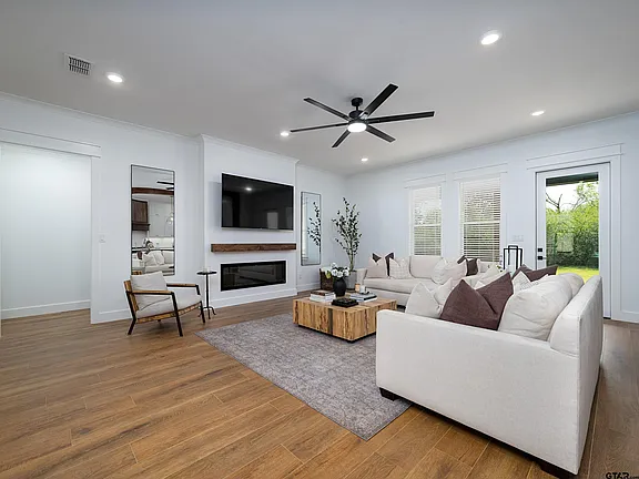 Living room with linear fireplace and hardwood floors