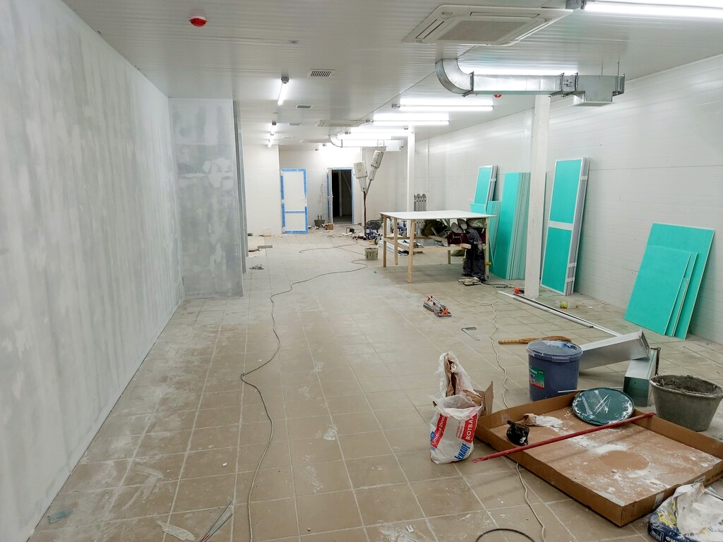 Commercial interior under construction with drywall and HVAC systems