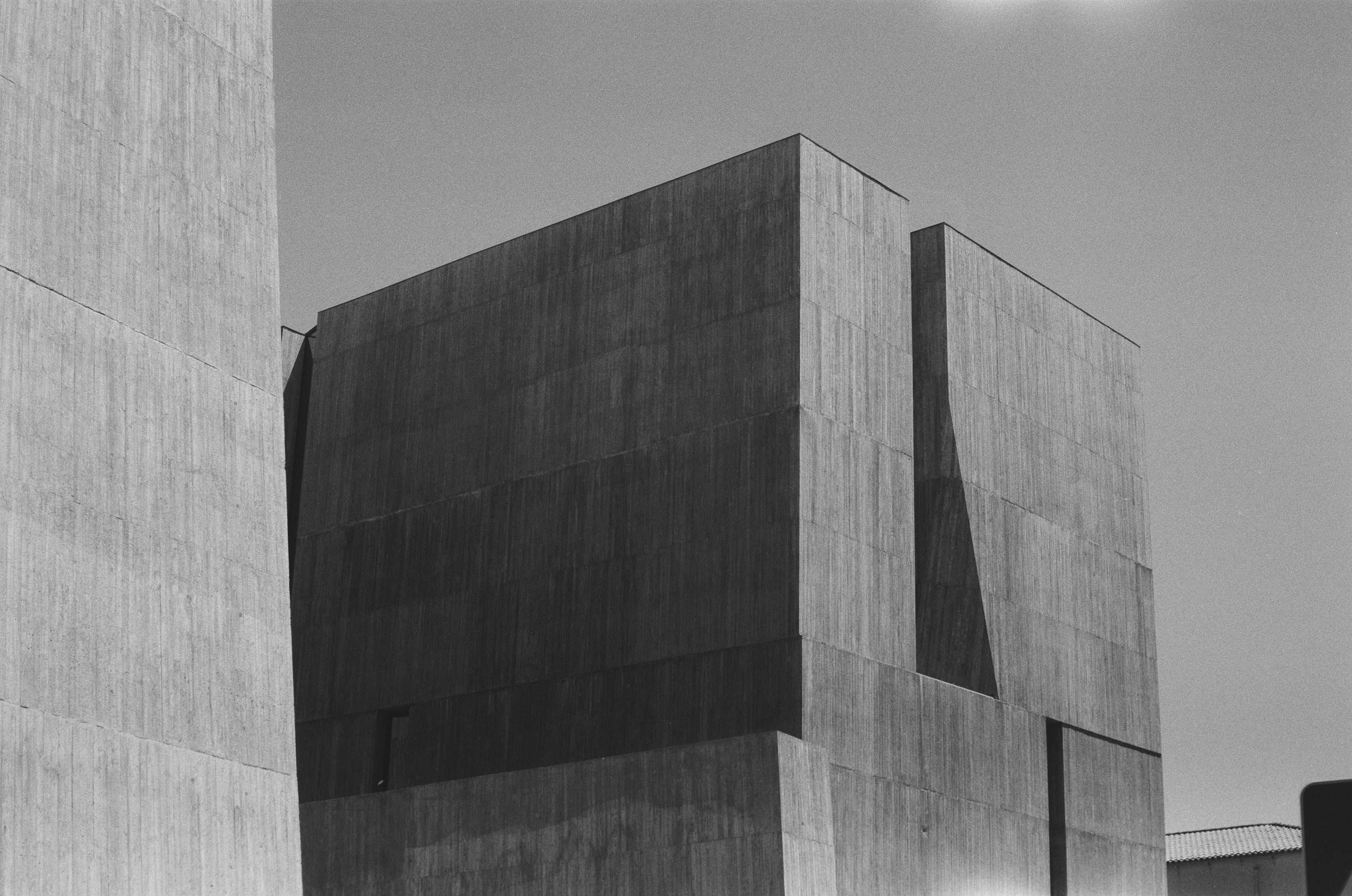 Black and white brutalist concrete building against a clear sky
