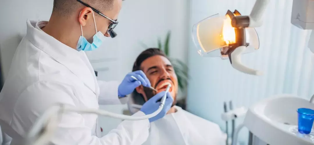 Dentist performing a procedure on a patient in a bright, modern operatory