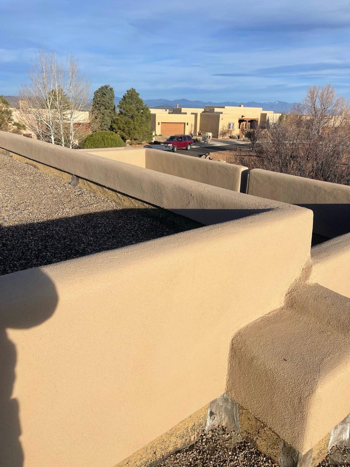 Completed rooftop parapet with smooth tan stucco finish
