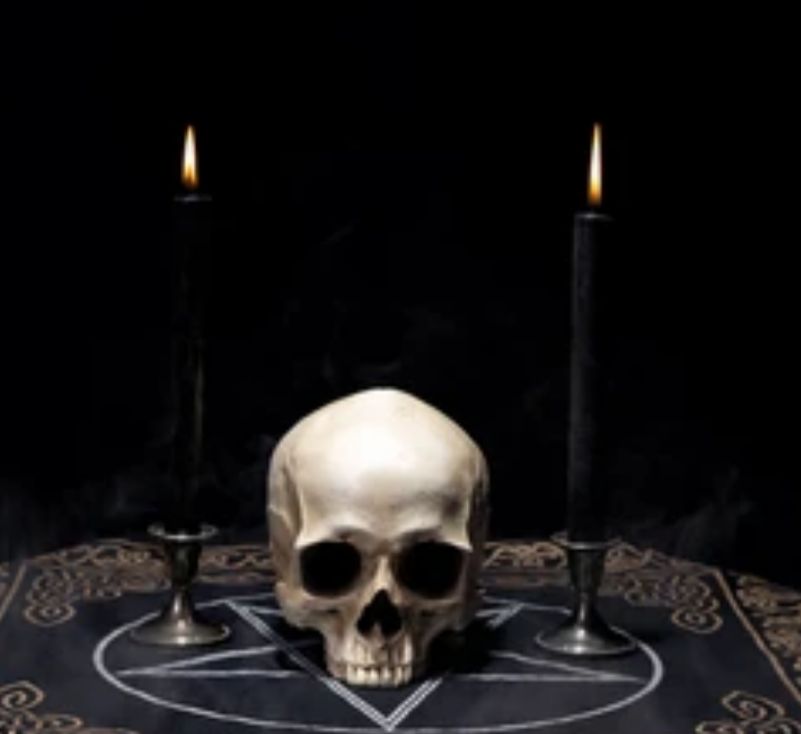 Cráneo con velas negras en altar ritual