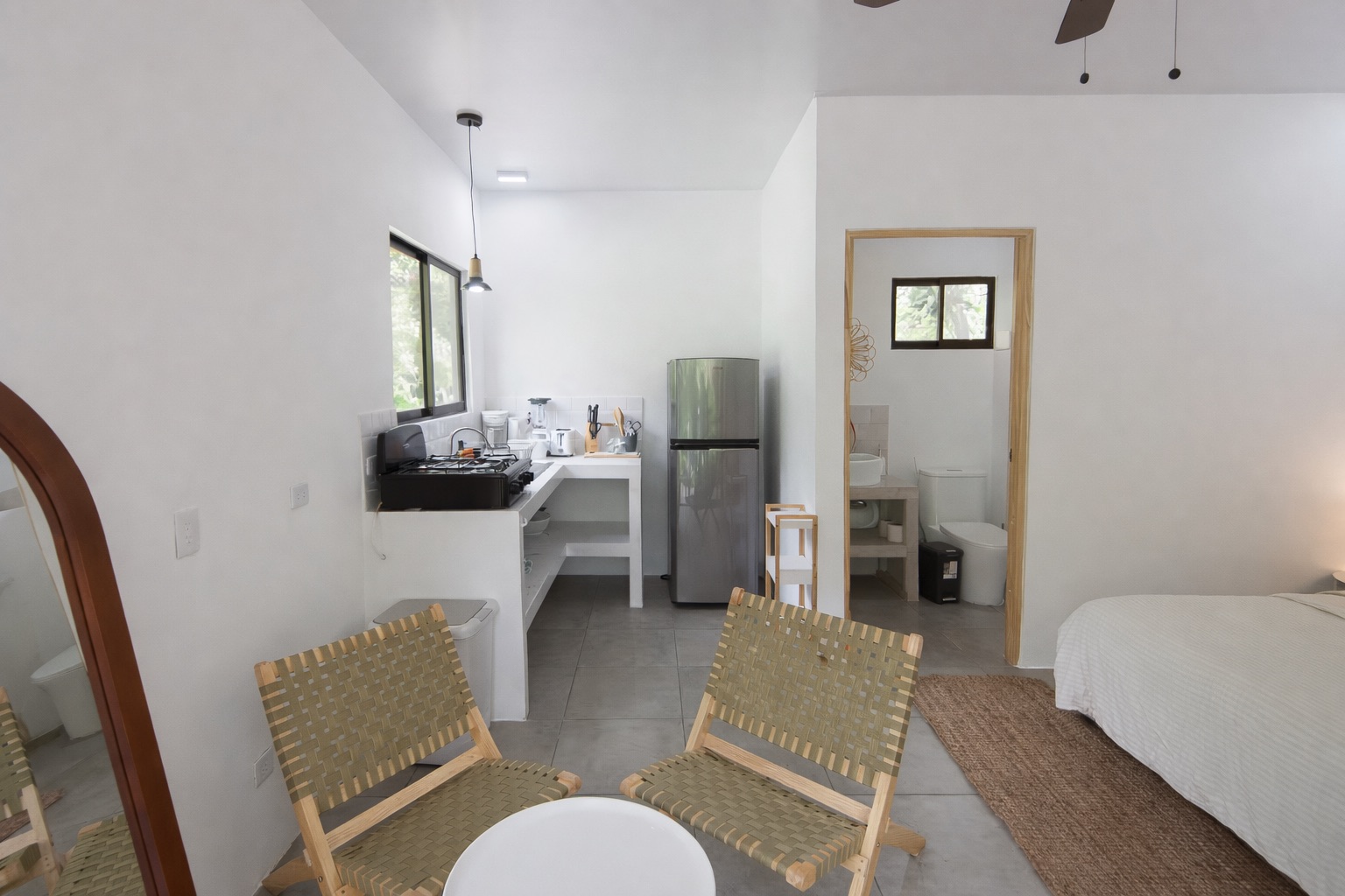 Open studio layout with living chairs, kitchen, and bathroom doorway visible