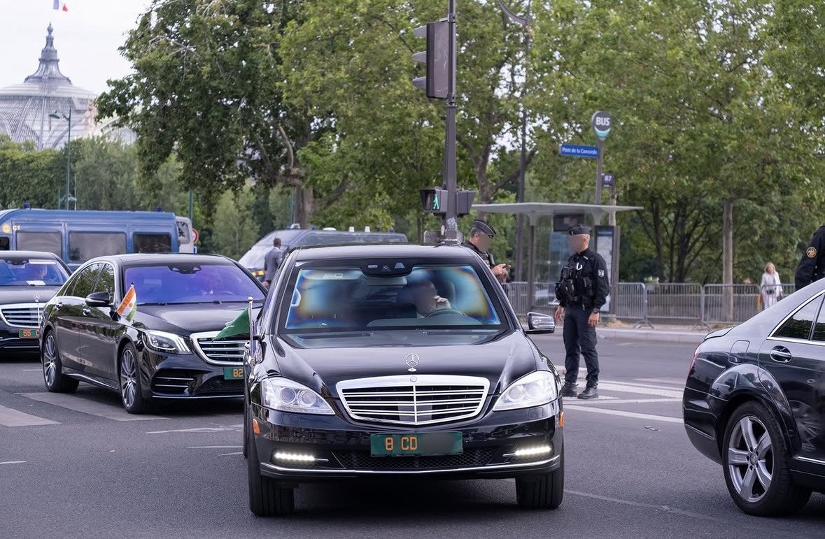 Plaque 8 CD — Arabie Saoudite, cortège officiel Pont de la Concorde, Paris Plaque diplomatique verte 8 CD sur une Mercedes S-Class noire au Pont de la Concorde à Paris — cortège officiel saoudien escorté par la police, drapeau de la Côte d'Ivoire visible sur un véhicule d'escorte