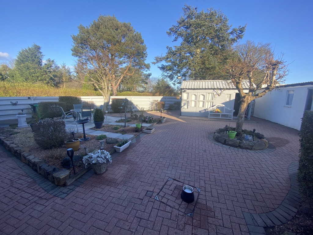 Pristine jet-washed courtyard paving with painted fencing and shed