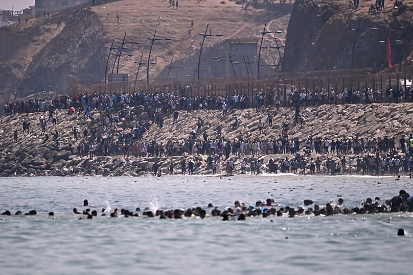 Thousands of migrants gathered on the hillside near the Ceuta border