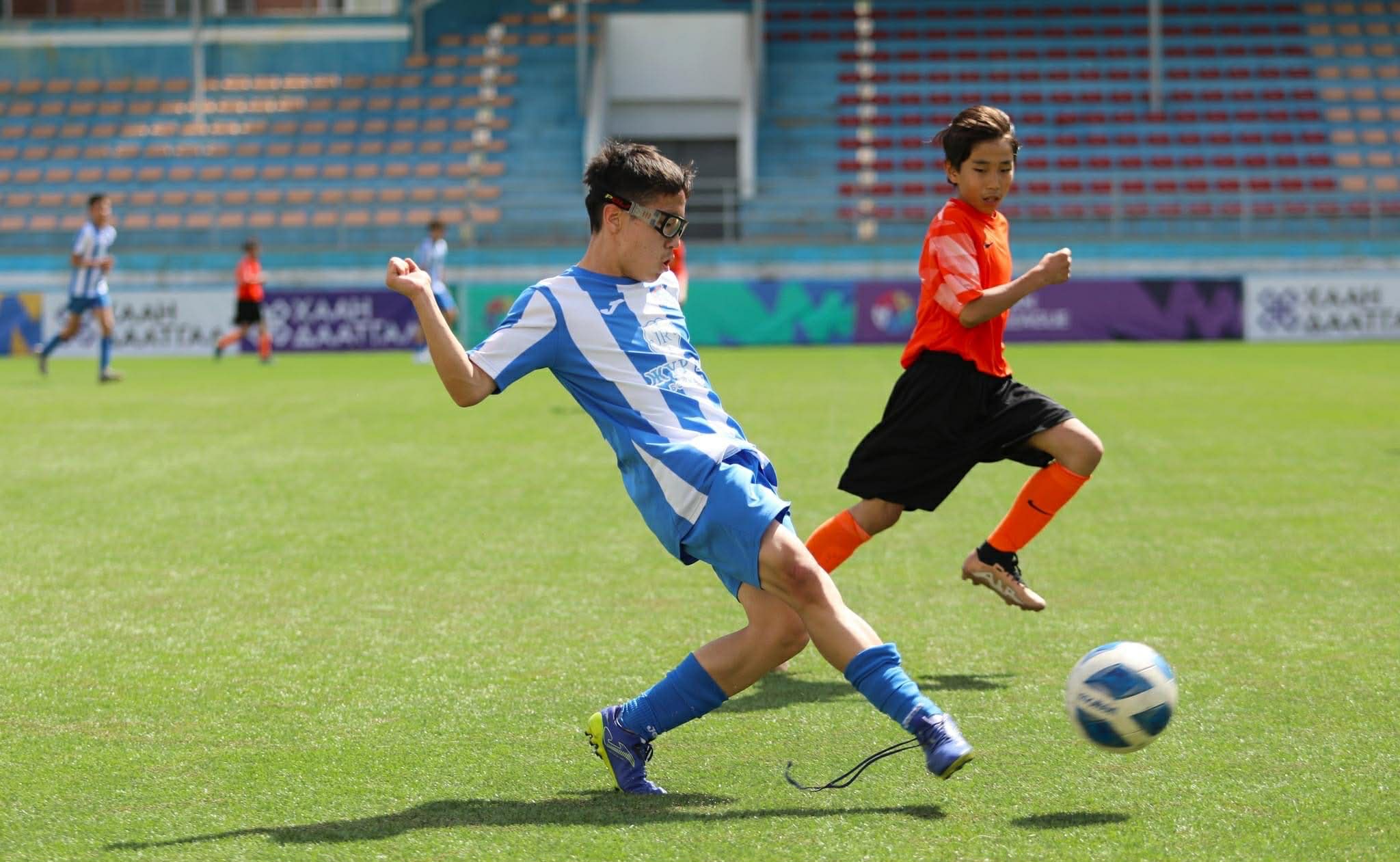 Erkhembold playing football in a stadium