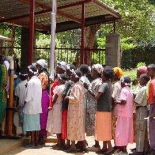 Lange Schlange wartender Frauen vor dem Eingangstor der Missionsstation
