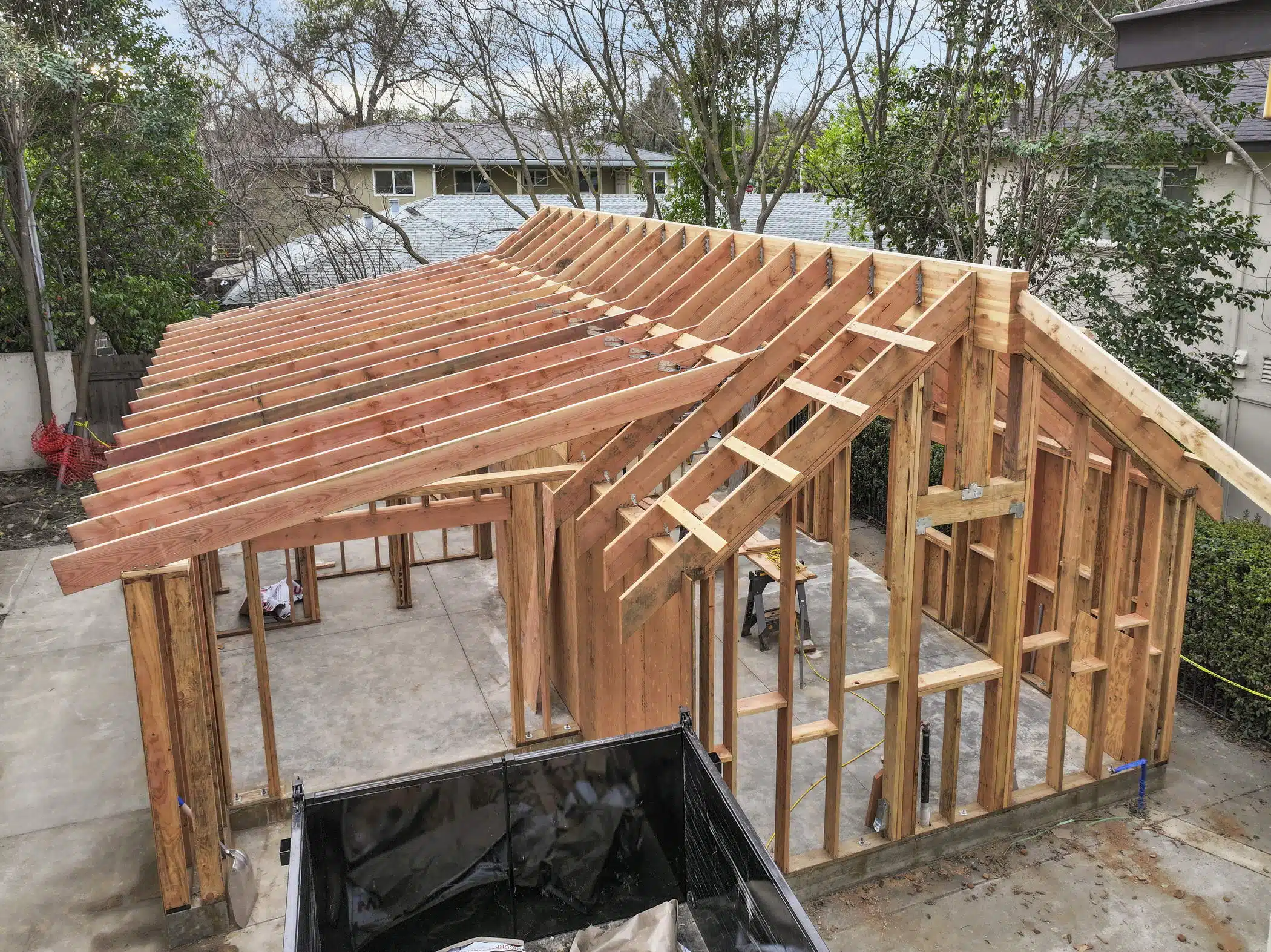 ADU during wood framing construction phase showing gable and shed roof rafter structure