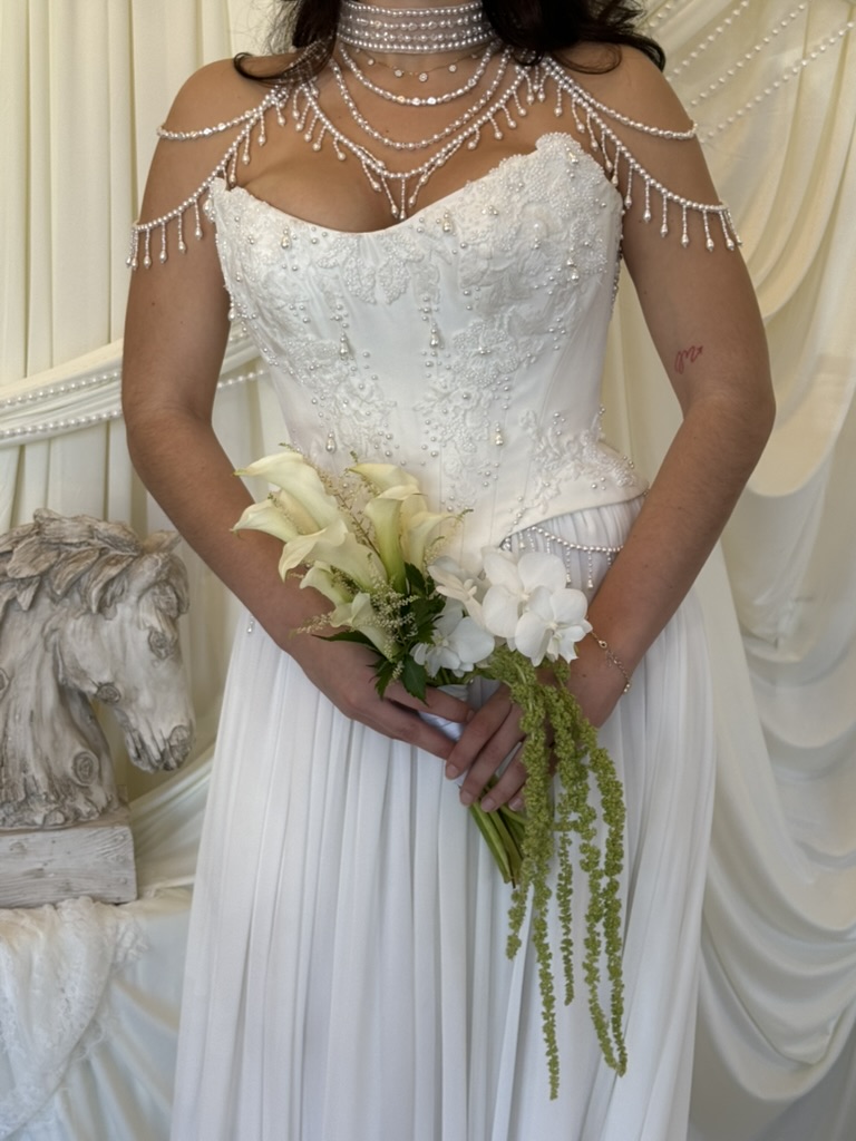 Bride holding calla lily and white orchid bouquet with trailing amaranthus greenery