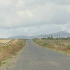 Leere Straße durch die kenianische Savanne bei Makuyu