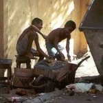 Zwei Kinder reparieren etwas an einer Mauer