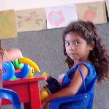 Mädchen mit lockigem Haar am Tisch