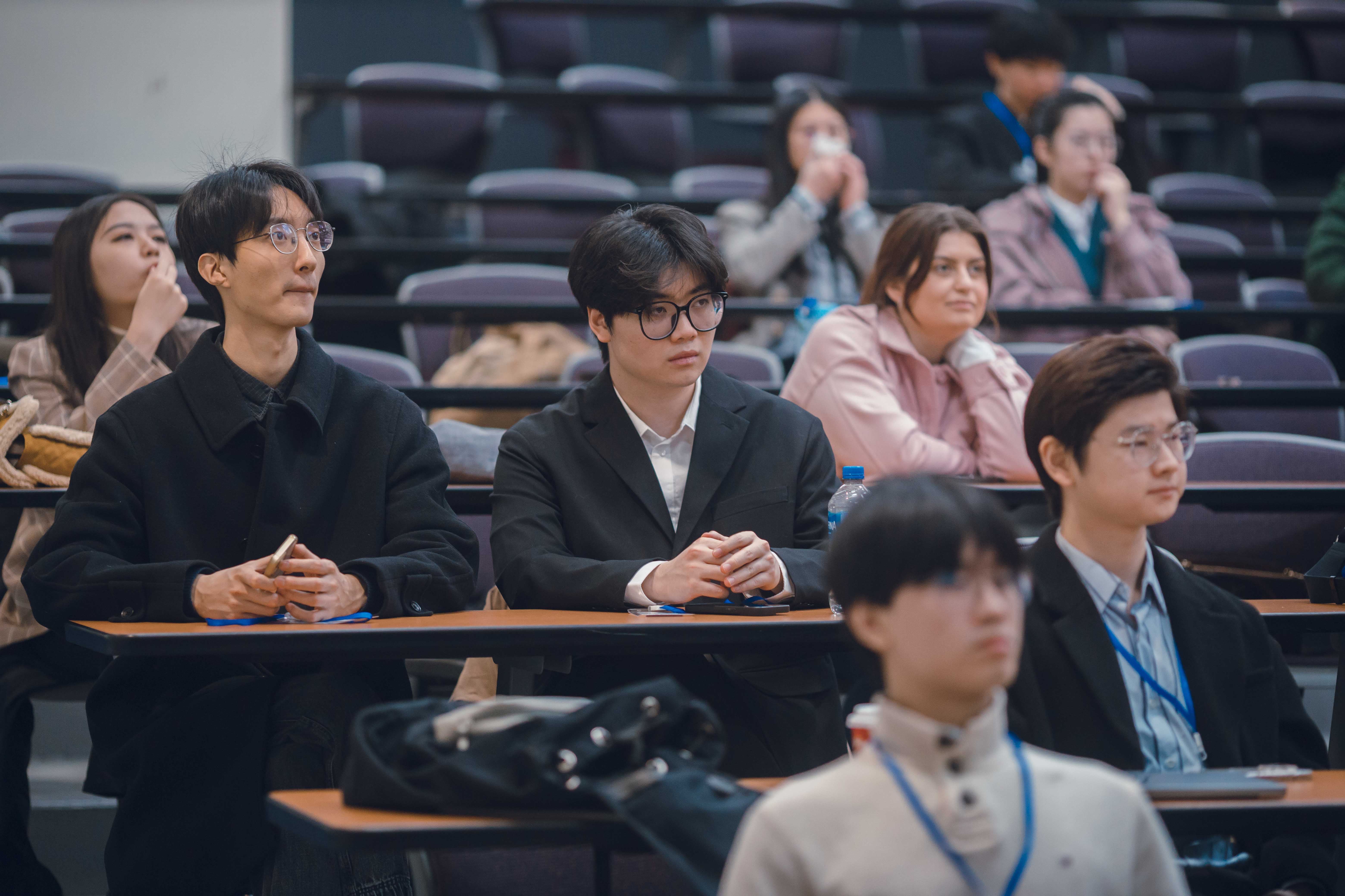 Founders and attendees listening together at an event in a lecture hall.