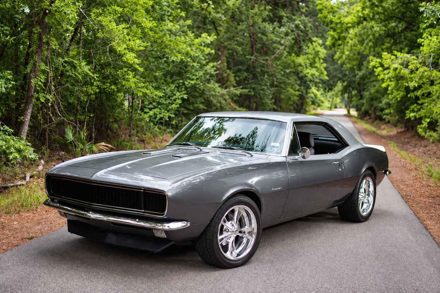 1967 Chevrolet Camaro clássico em uma estrada arborizada