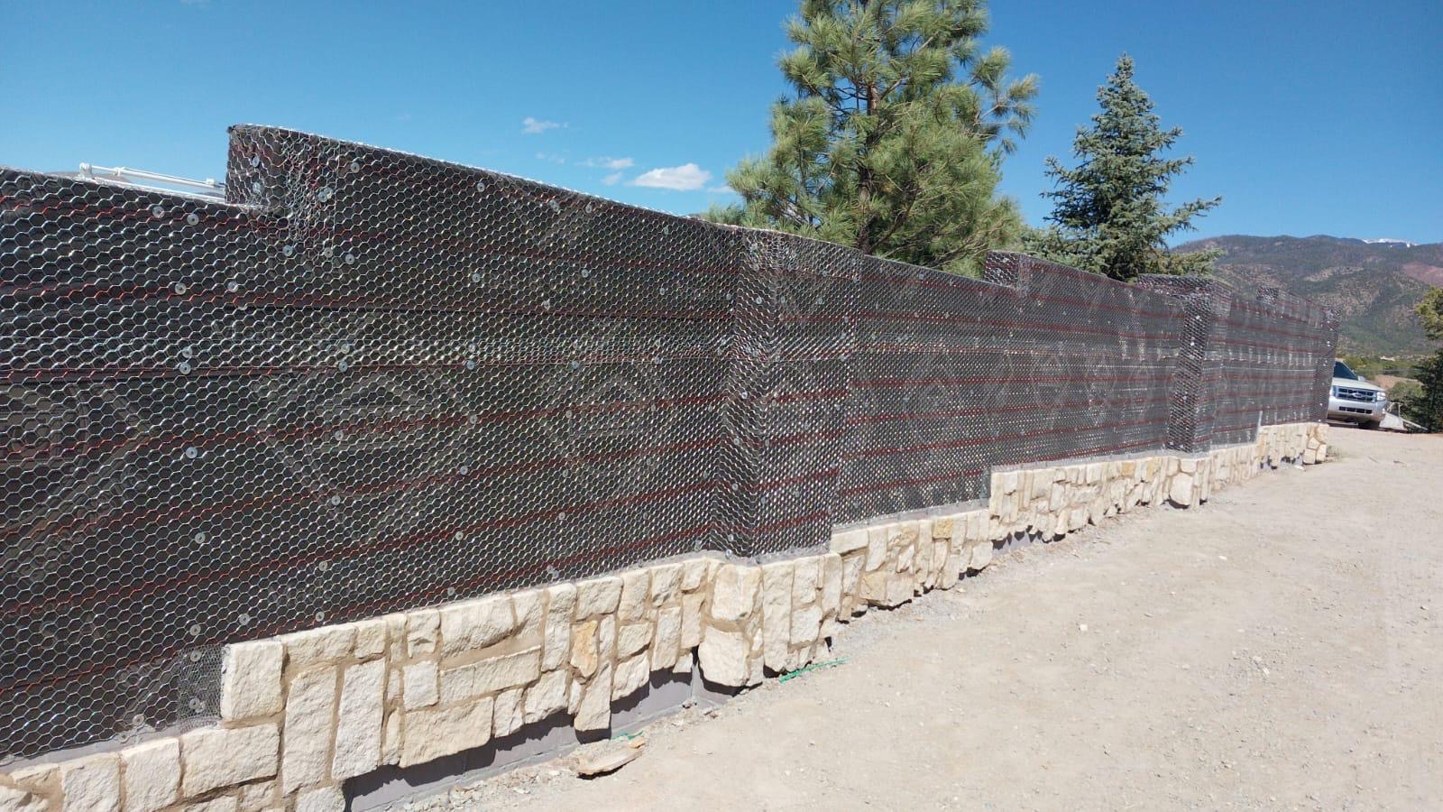 Wall preparation with wire mesh lath over stone foundation before stucco