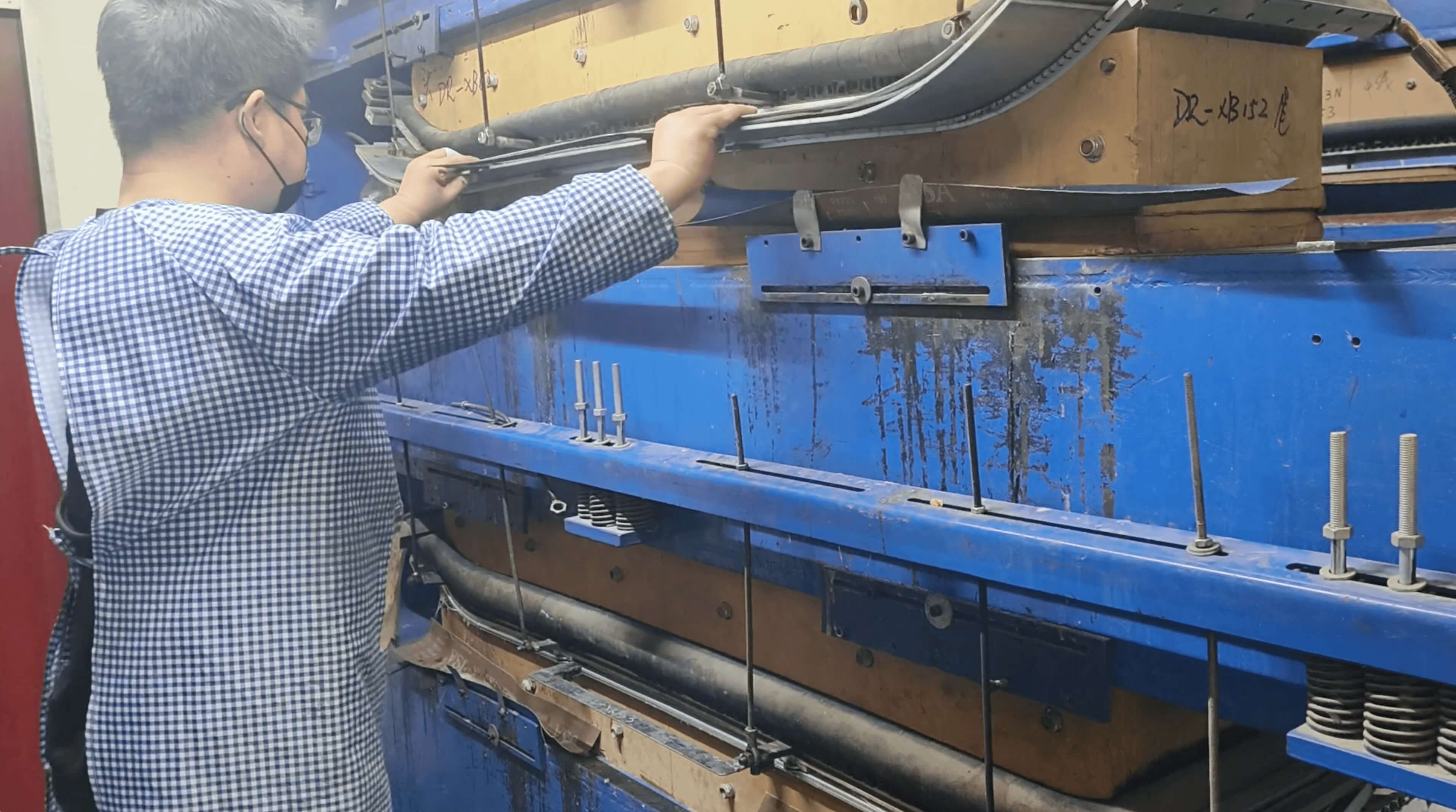 Technician operating the hydraulic press machine for board curing