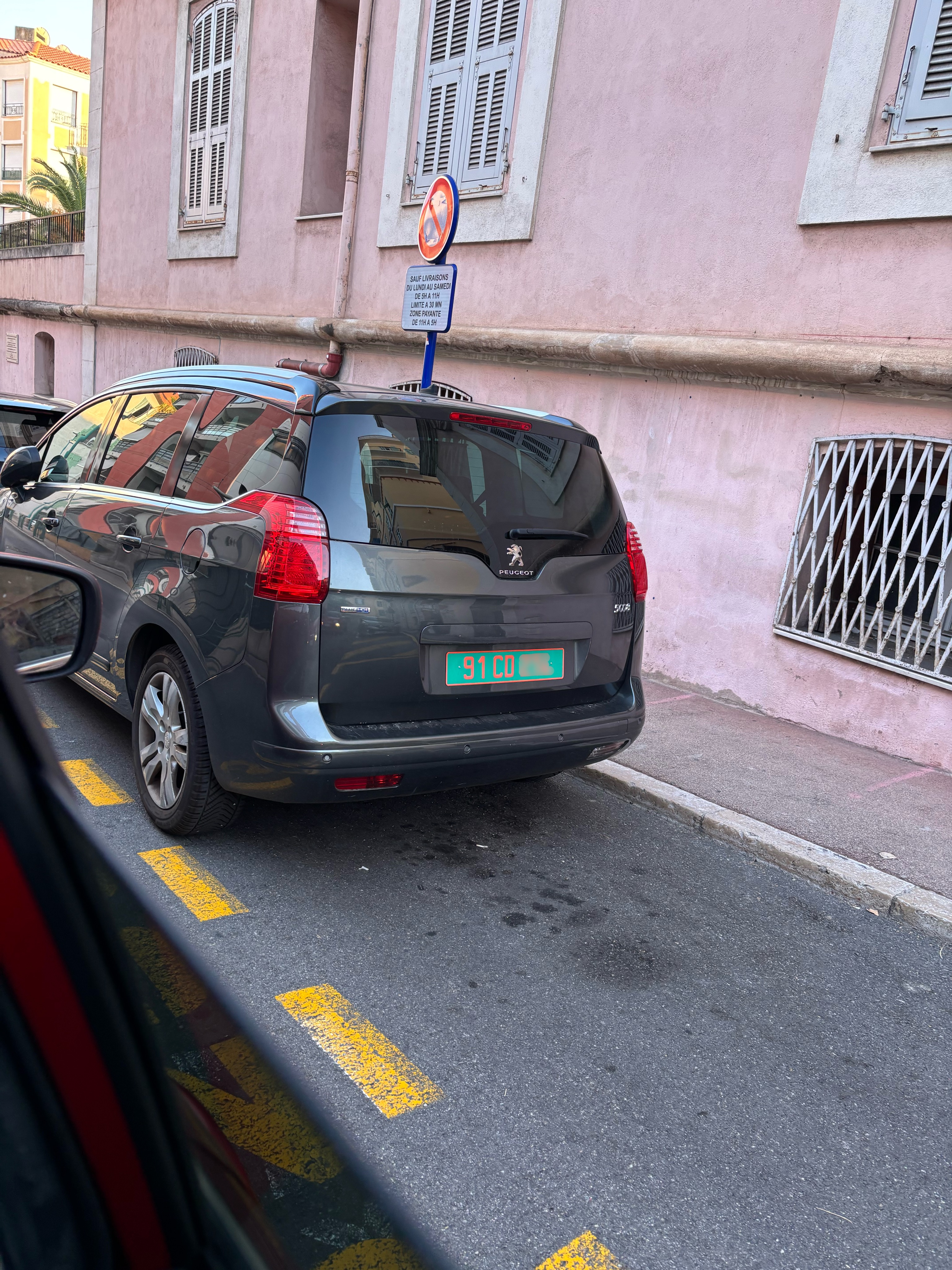 Plaque 91 CD — Pérou, corps diplomatique Plaque diplomatique verte 91 CD sur un Peugeot 5008 gris garé dans une ruelle — code 91 correspondant au Pérou