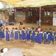Schulkinder in blauen Uniformen bei einer Schulveranstaltung