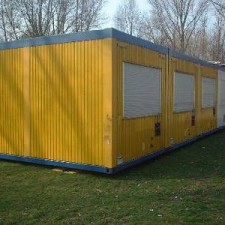 Gelber Computainer vor Aufstellung auf der Wiese