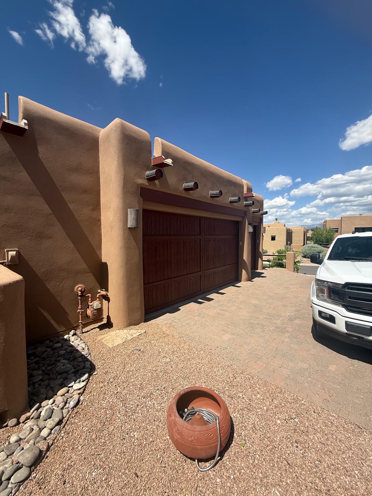 Garage exterior with smooth stucco finish and traditional vigas