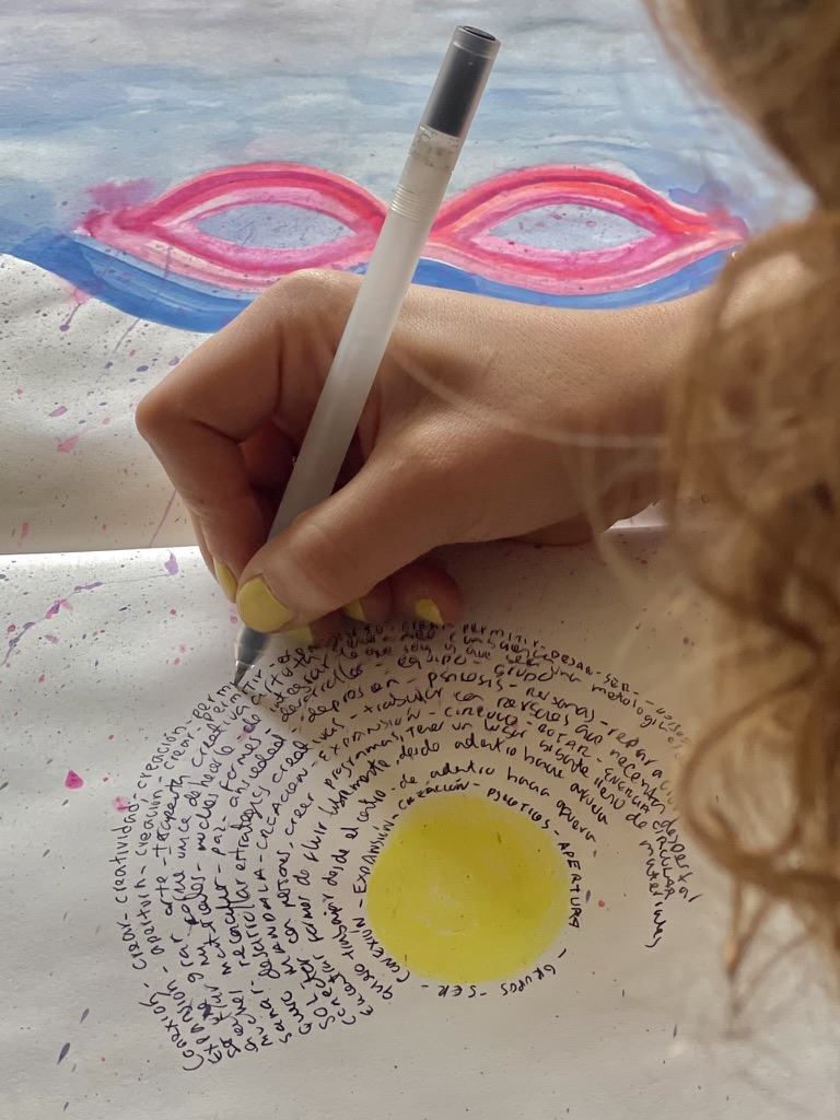 Mano escribiendo texto en espiral alrededor de círculo amarillo