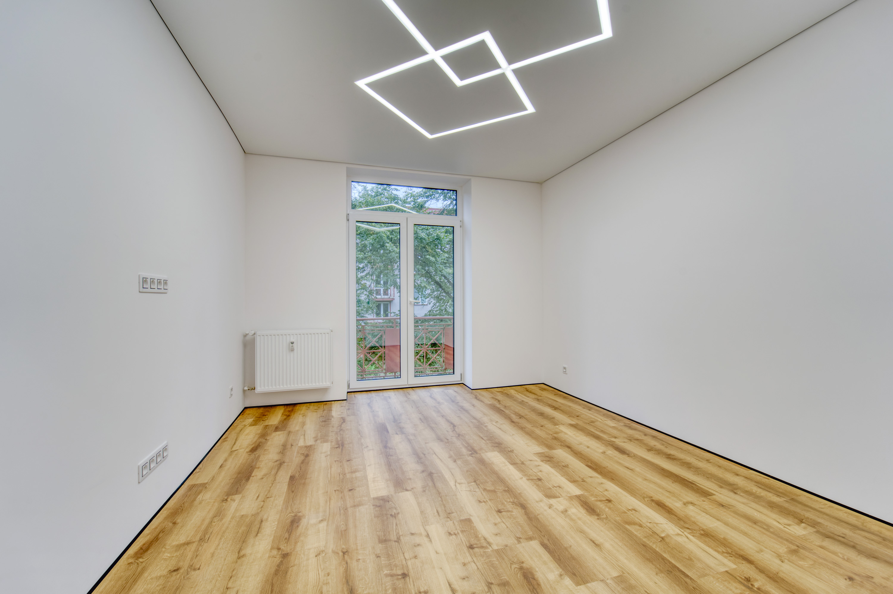 Empty bright room with wood flooring and balcony door