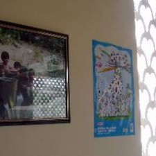 Kinderzeichnung und Foto an der Wand