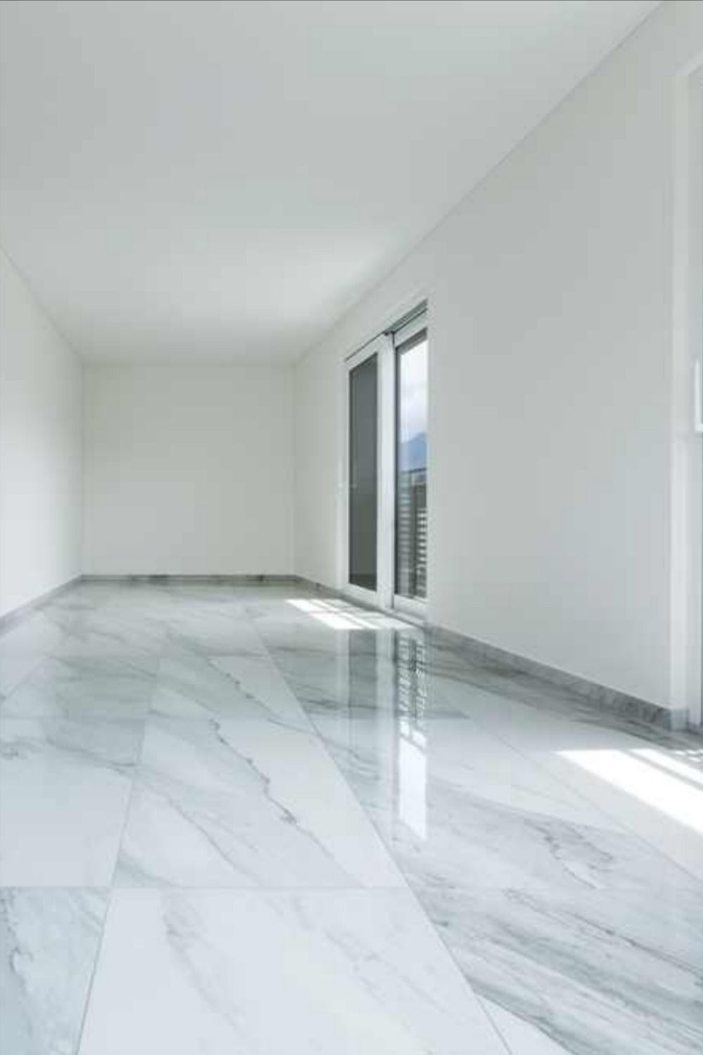 Sol en marbre blanc poli avec veines grises subtiles dans une piece lumineuse moderne