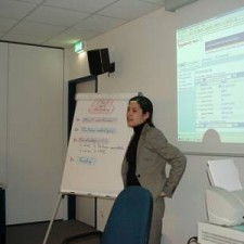 Referentin vor Flipchart und Beamer-Präsentation