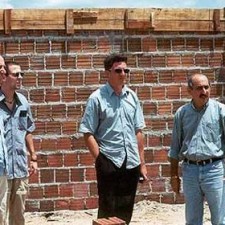 Drei Männer vor einer Backsteinmauer im Bau