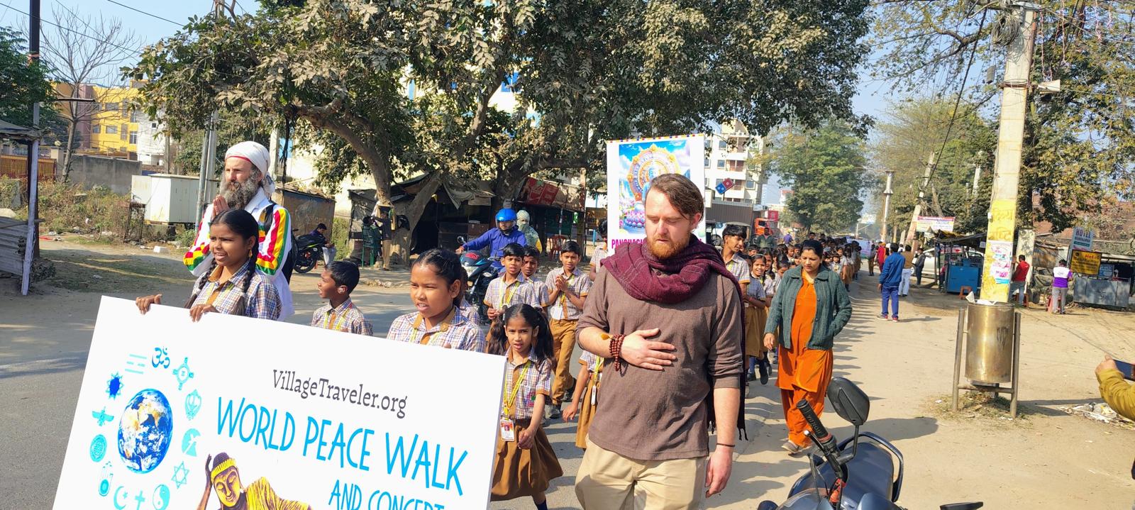 World Peace Walk with schoolchildren and Village Traveler banner marching through the streets