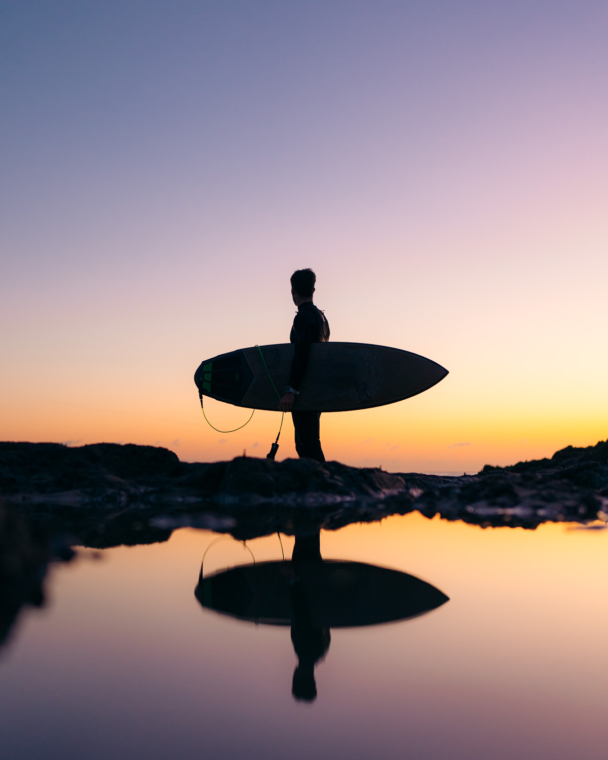 Silhouette d'un surfeur au coucher du soleil