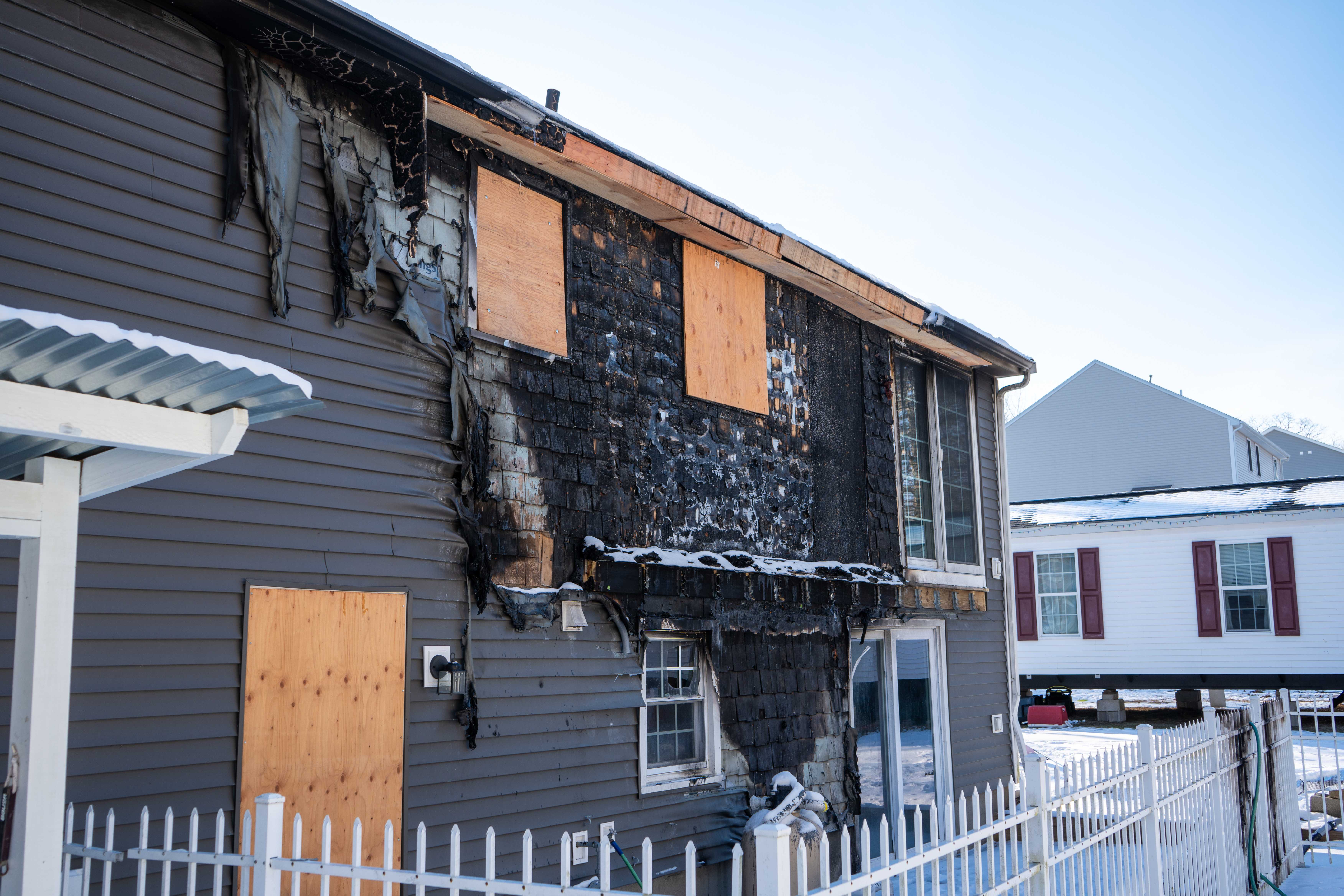 Fire-damaged residential home with boarded windows