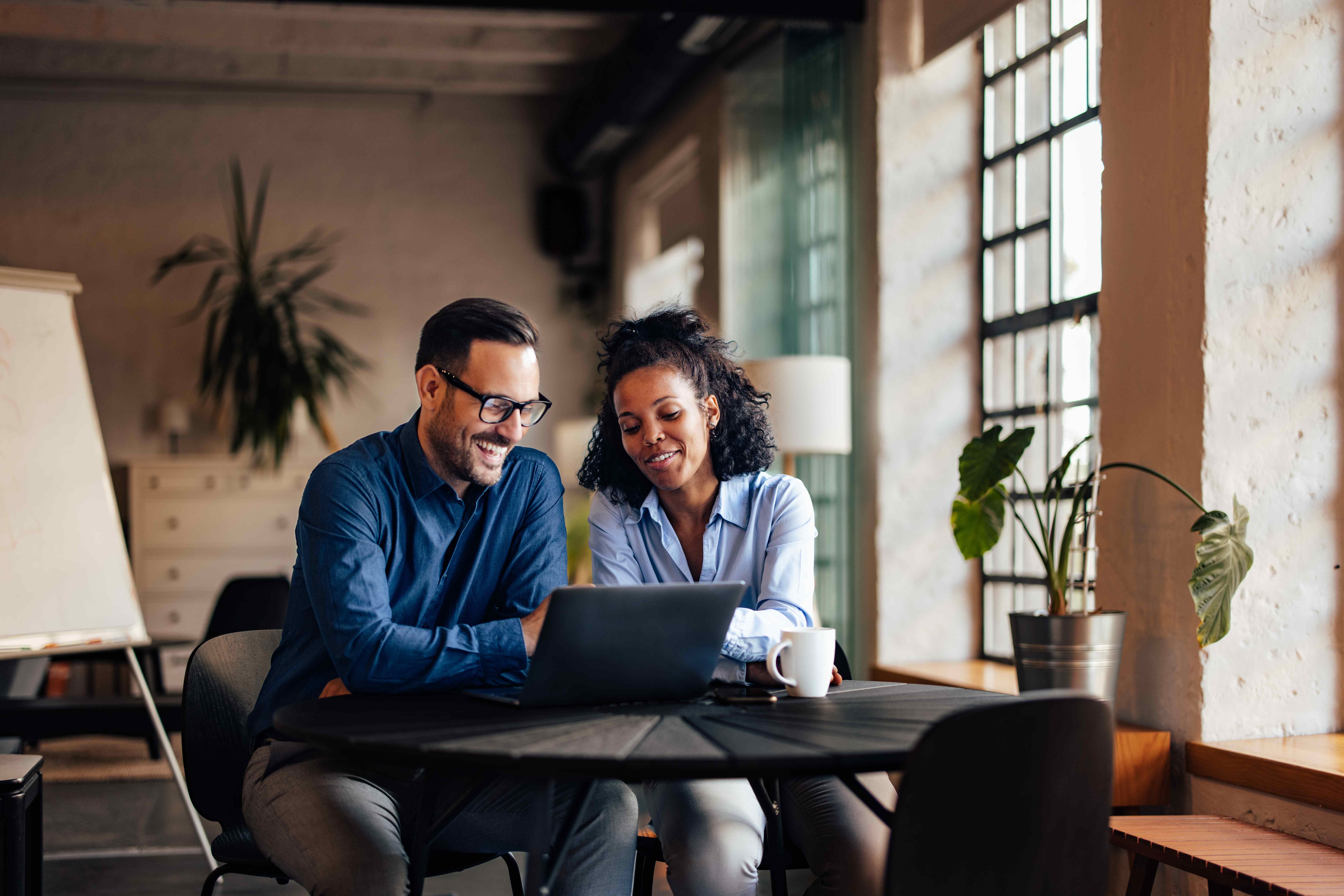 Professionals collaborating on investment strategy with laptop