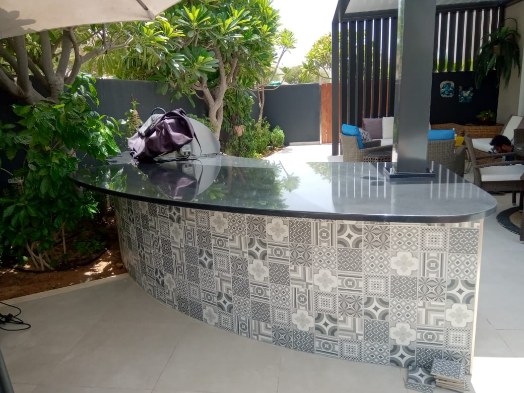 Outdoor kitchen and dining area within a designed garden