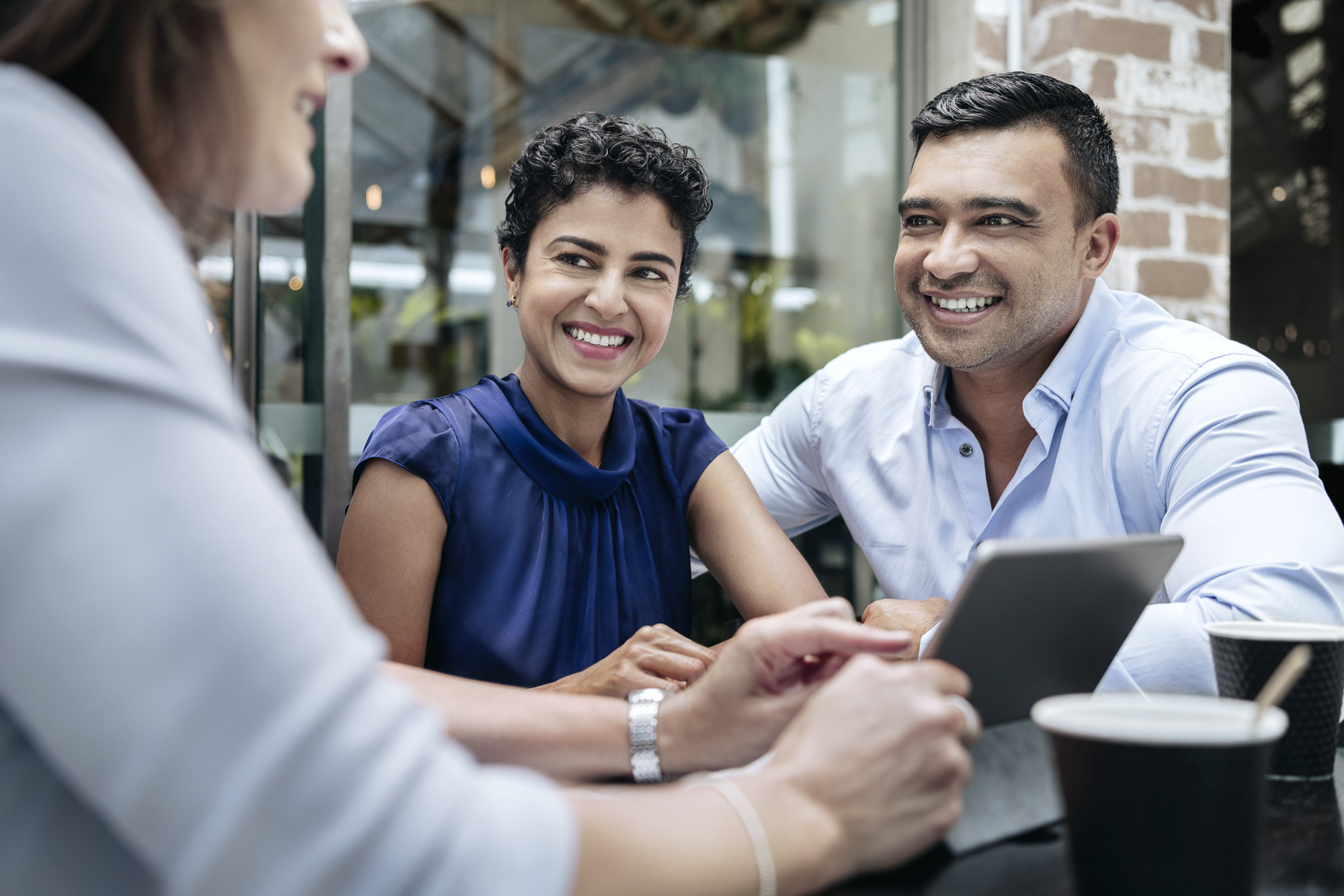 Professionals collaborating on property sale strategy with tablet