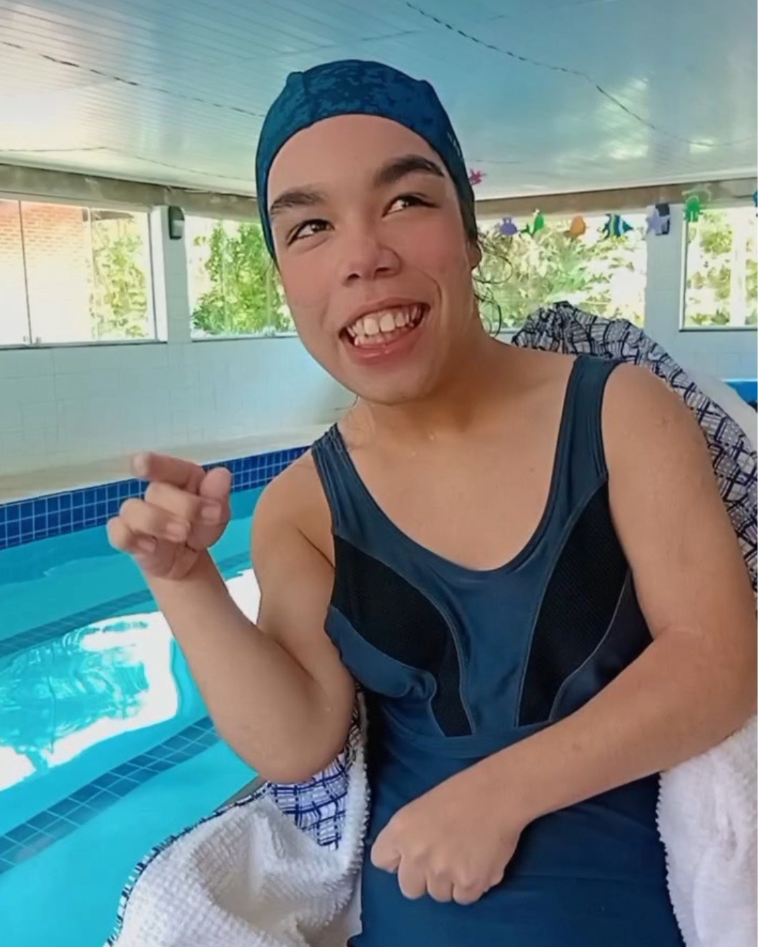 Bruna sorrindo na piscina durante uma atividade aquática.