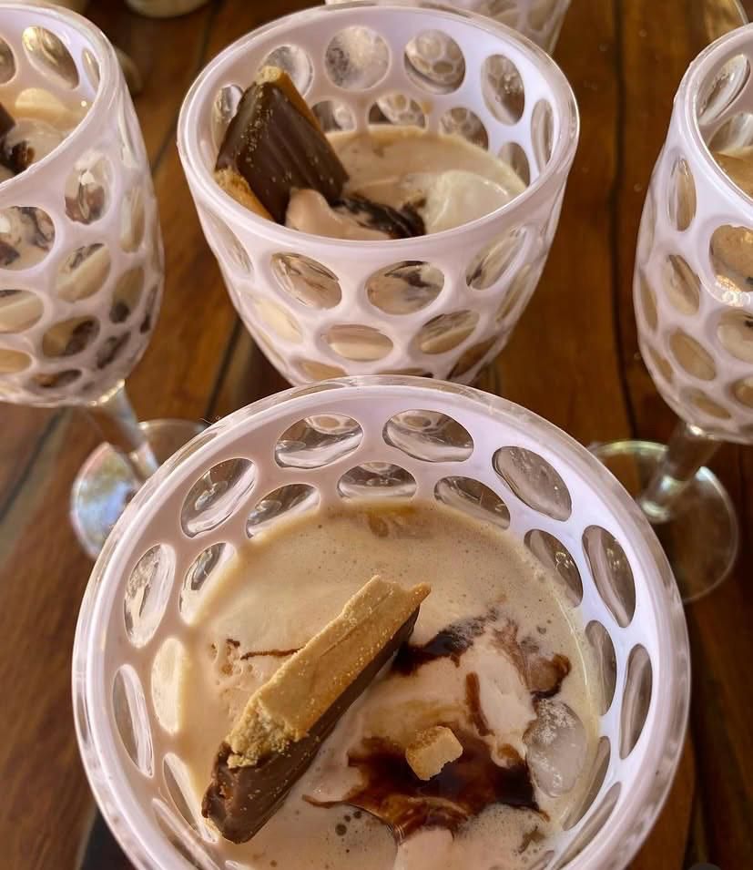 Copas de vidrio calado con affogato de helado de vainilla, café y brownie de chocolate sobre una mesa de madera