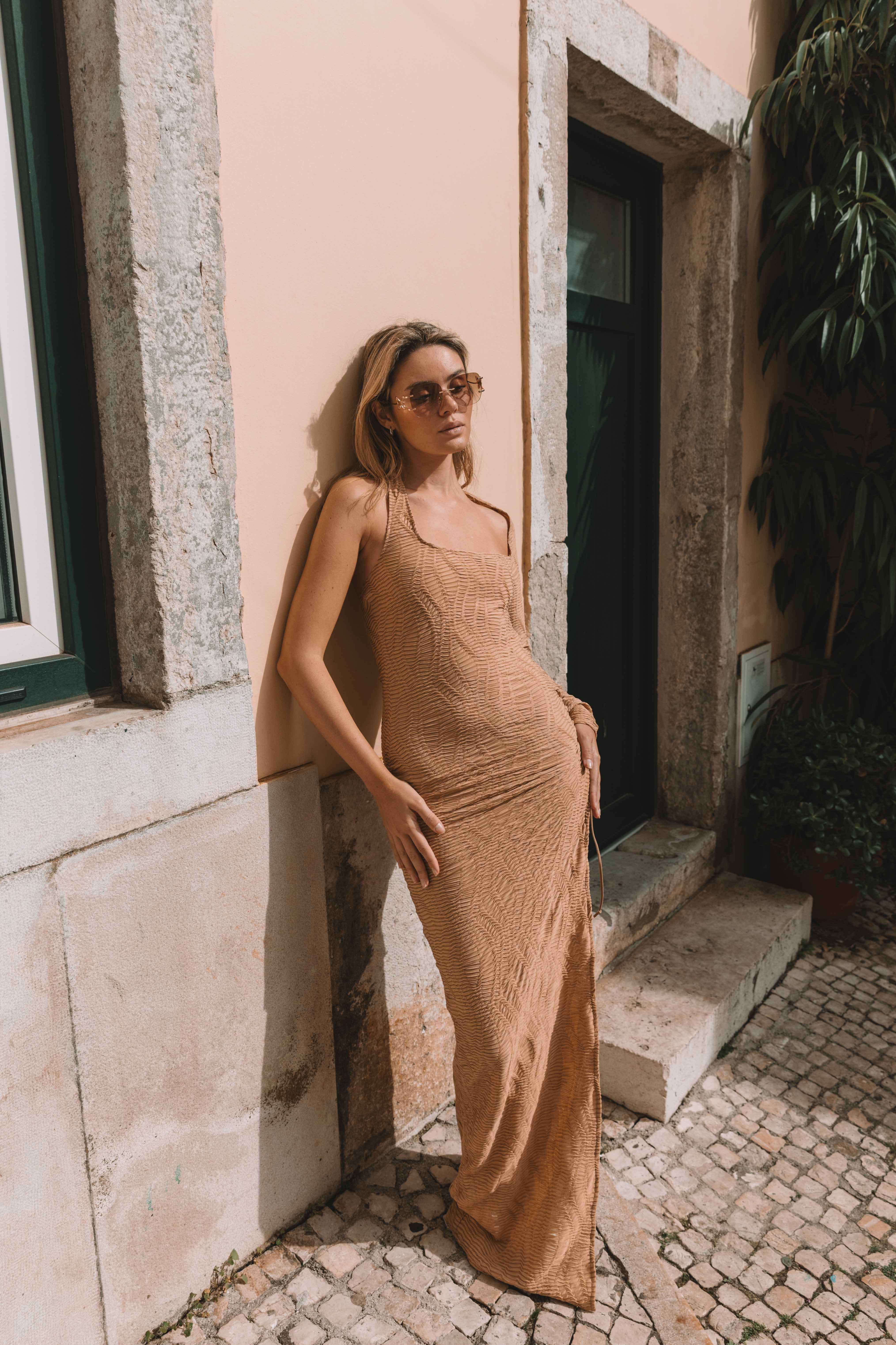 Model in tan textured maxi dress pink wall Lisbon