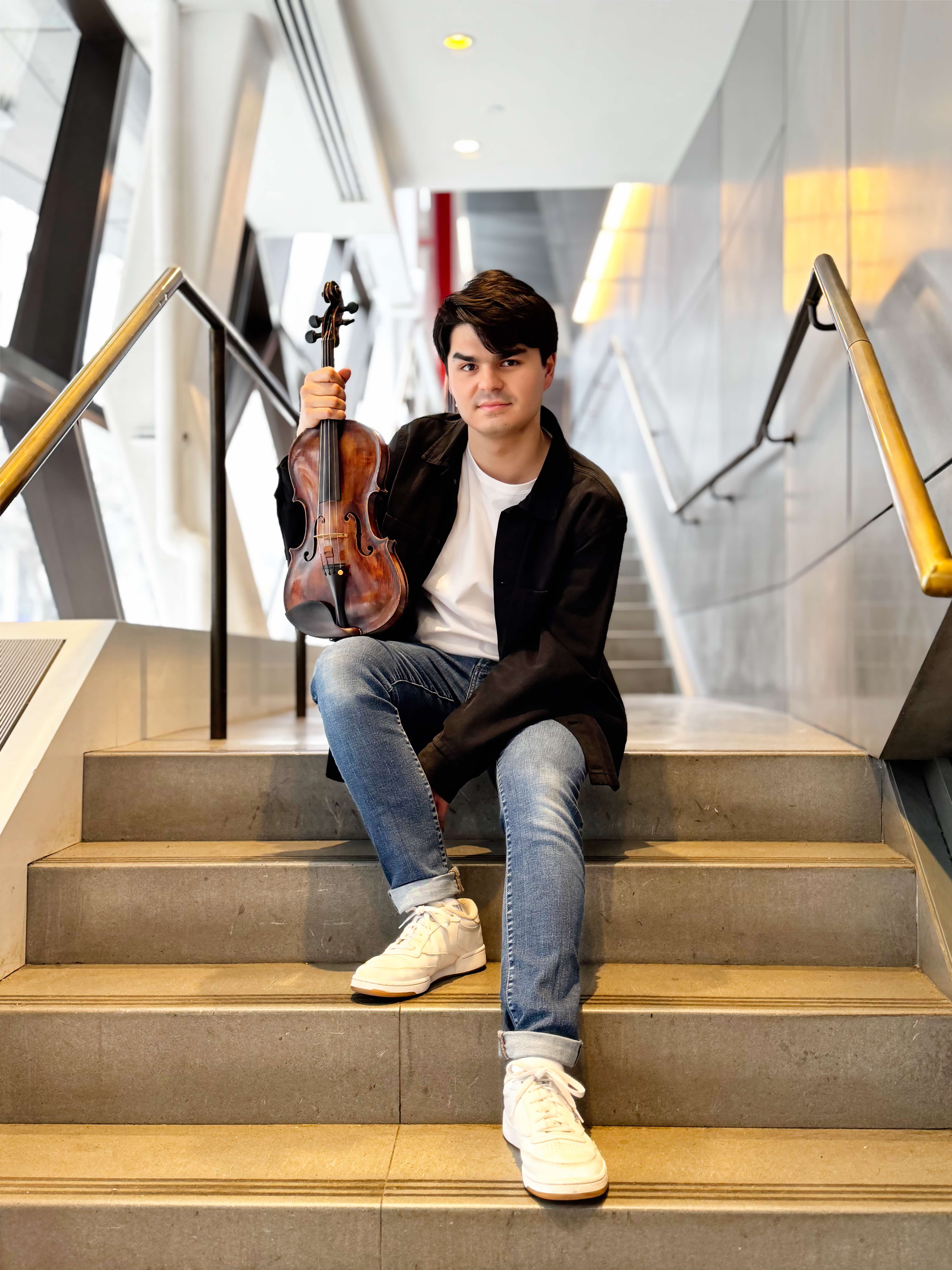 Avery Scott on stairs holding violin