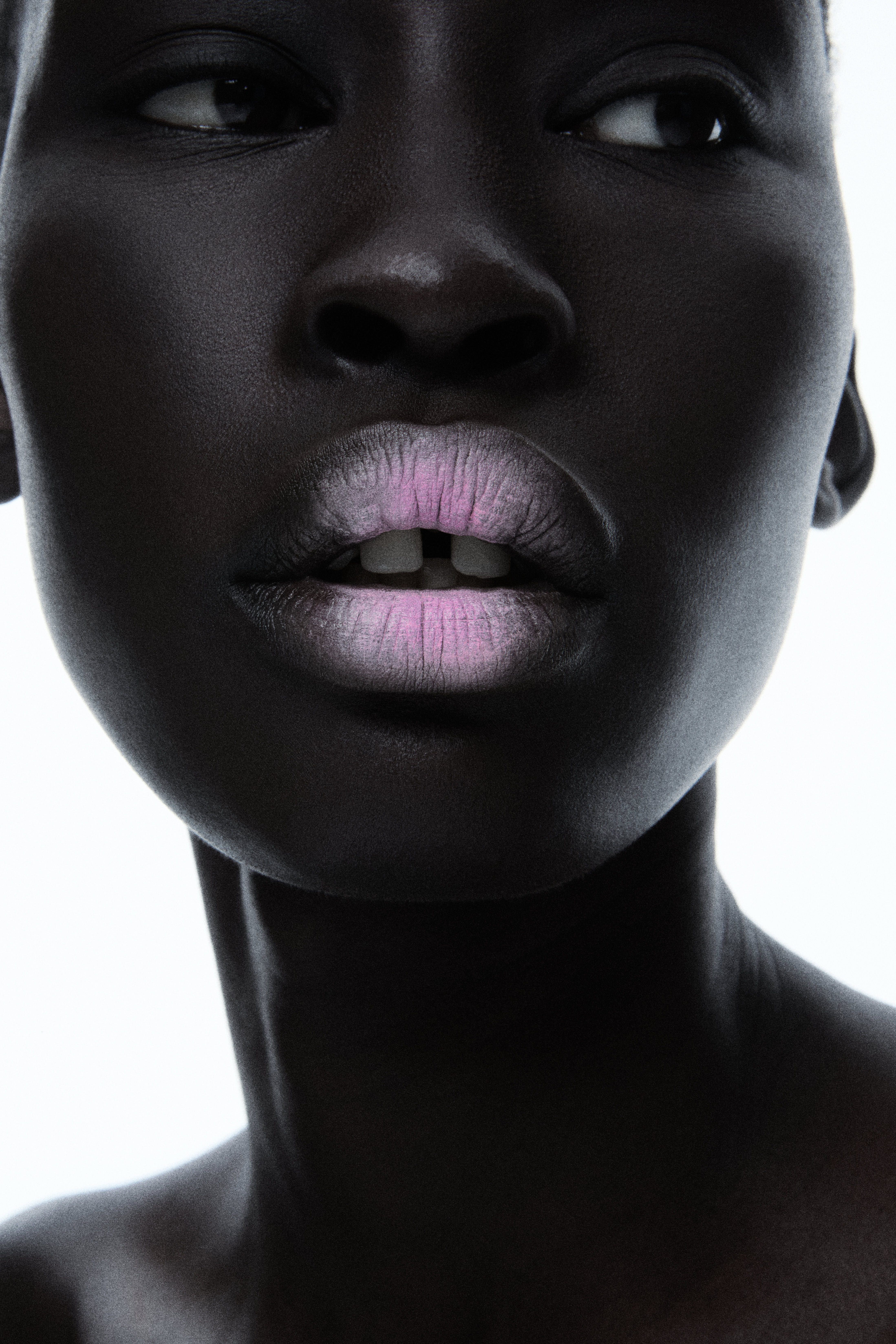 High-key beauty close-up of model with pink-toned lips against white