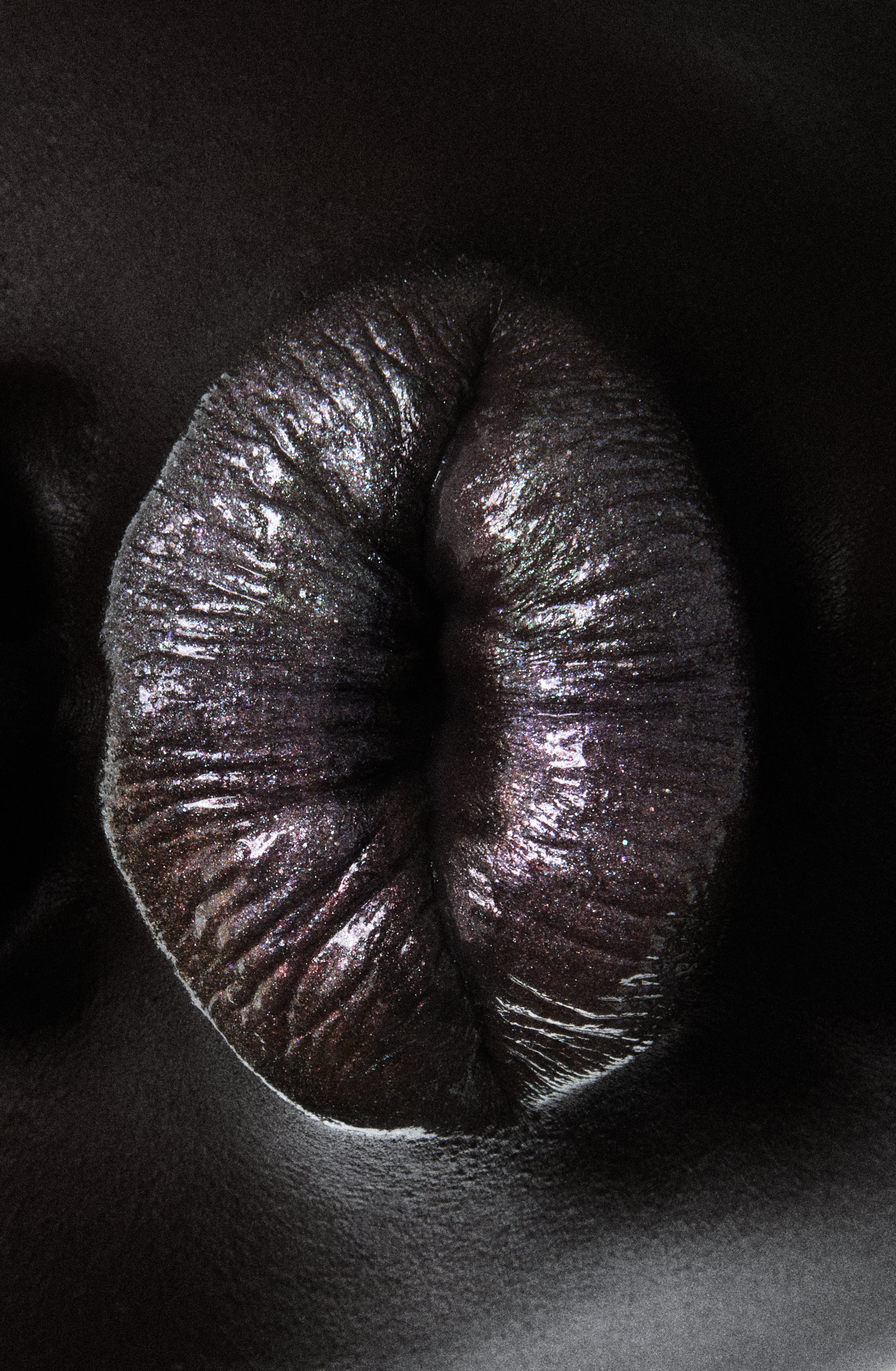 Extreme macro of glittering iridescent lips on dark skin