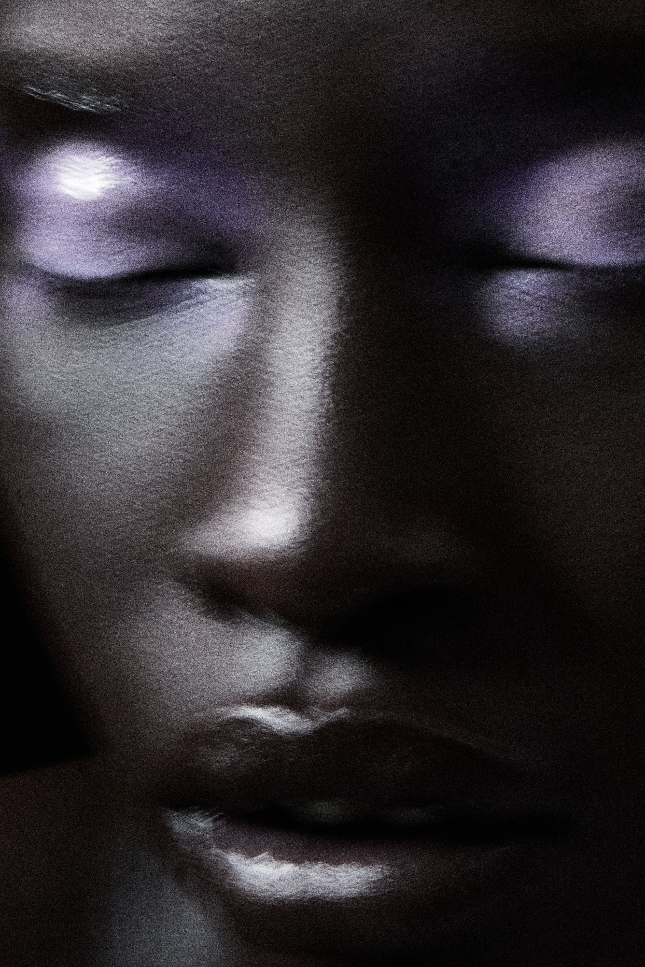 Motion-blurred beauty close-up of face with closed eyes and lavender highlights