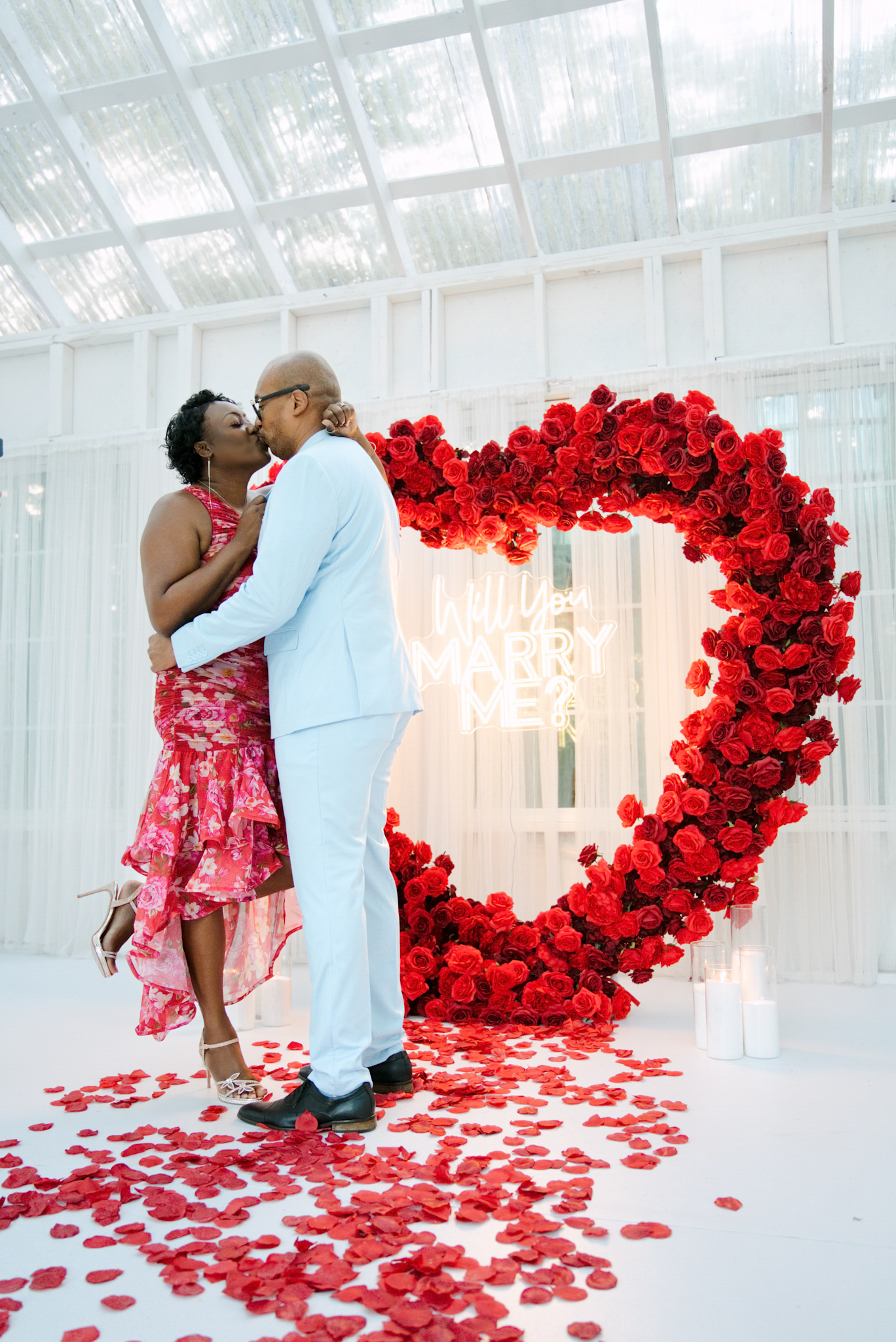 Couple sharing an intimate embrace in the glass house
