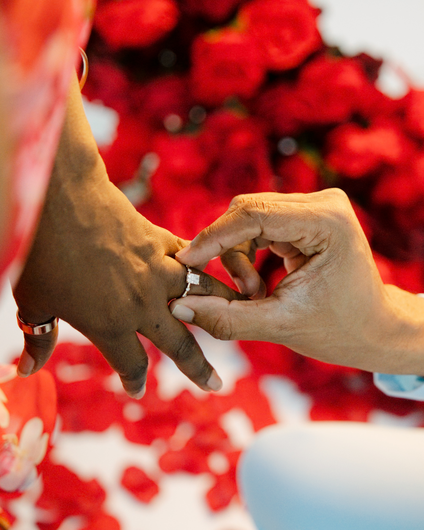 Close-up of an engagement ring being placed on the finger