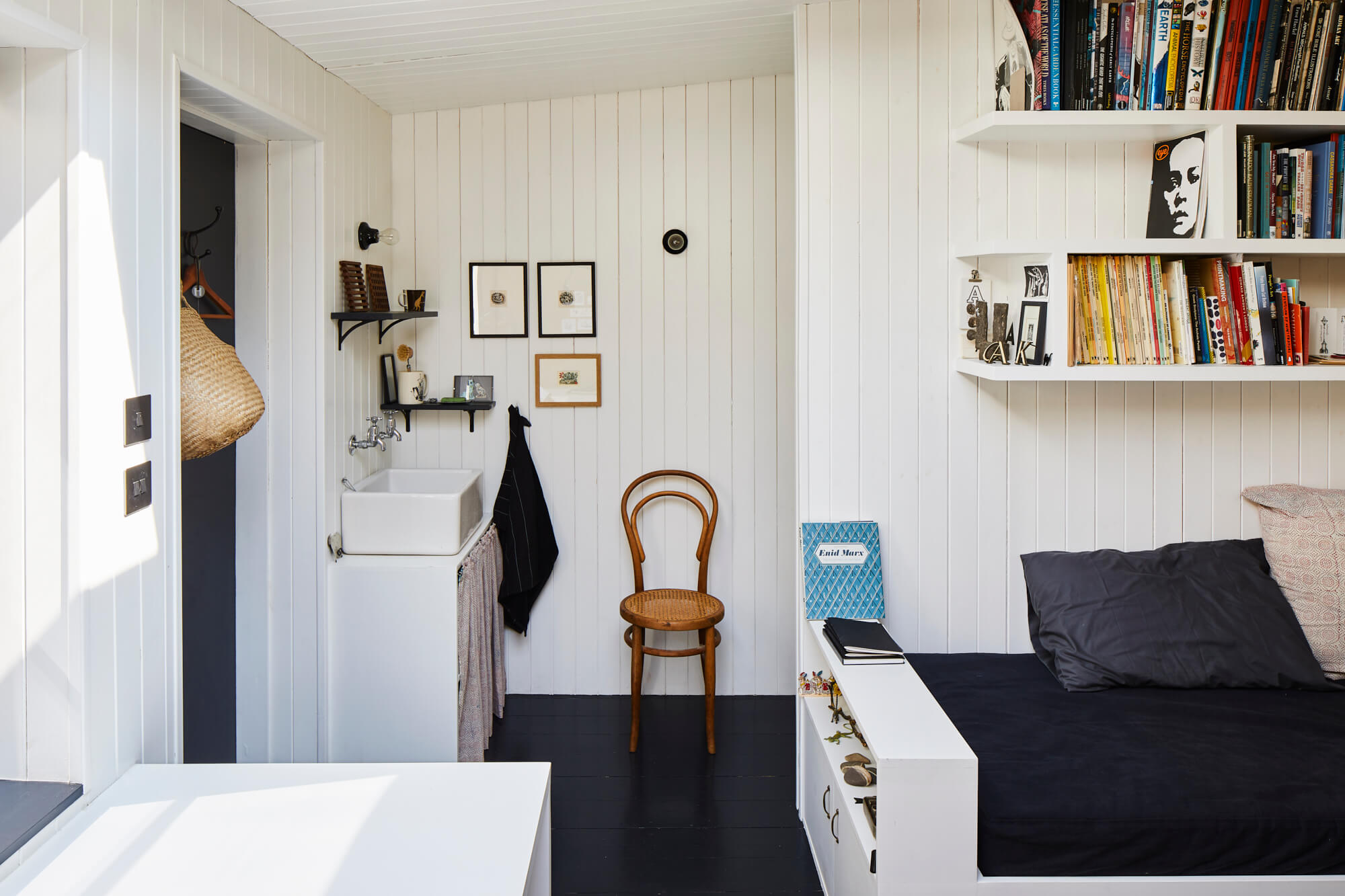 Bedroom study area with built-in storage, sink, and black painted floors