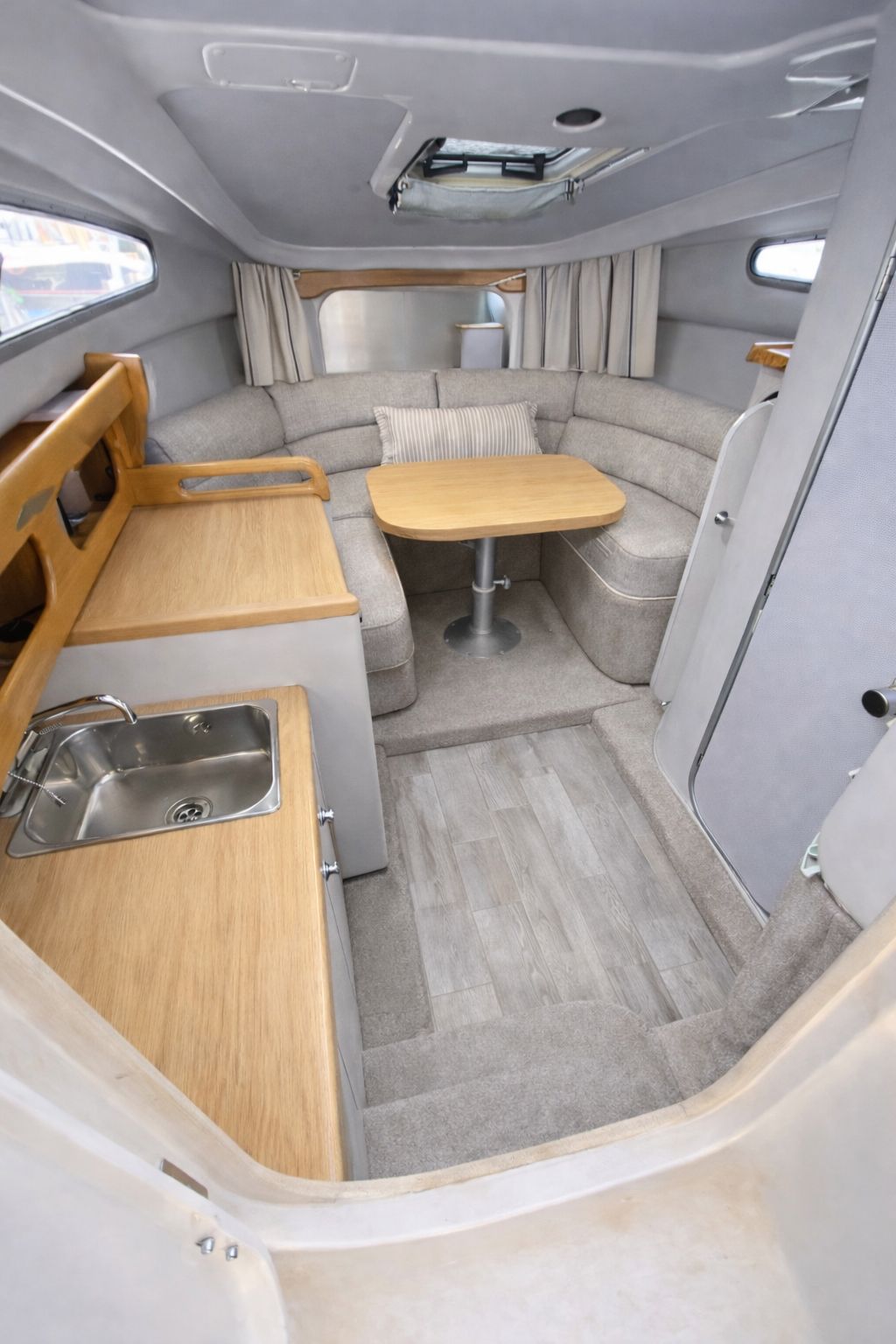The galley and saloon below deck with sink, oak worktop and seating